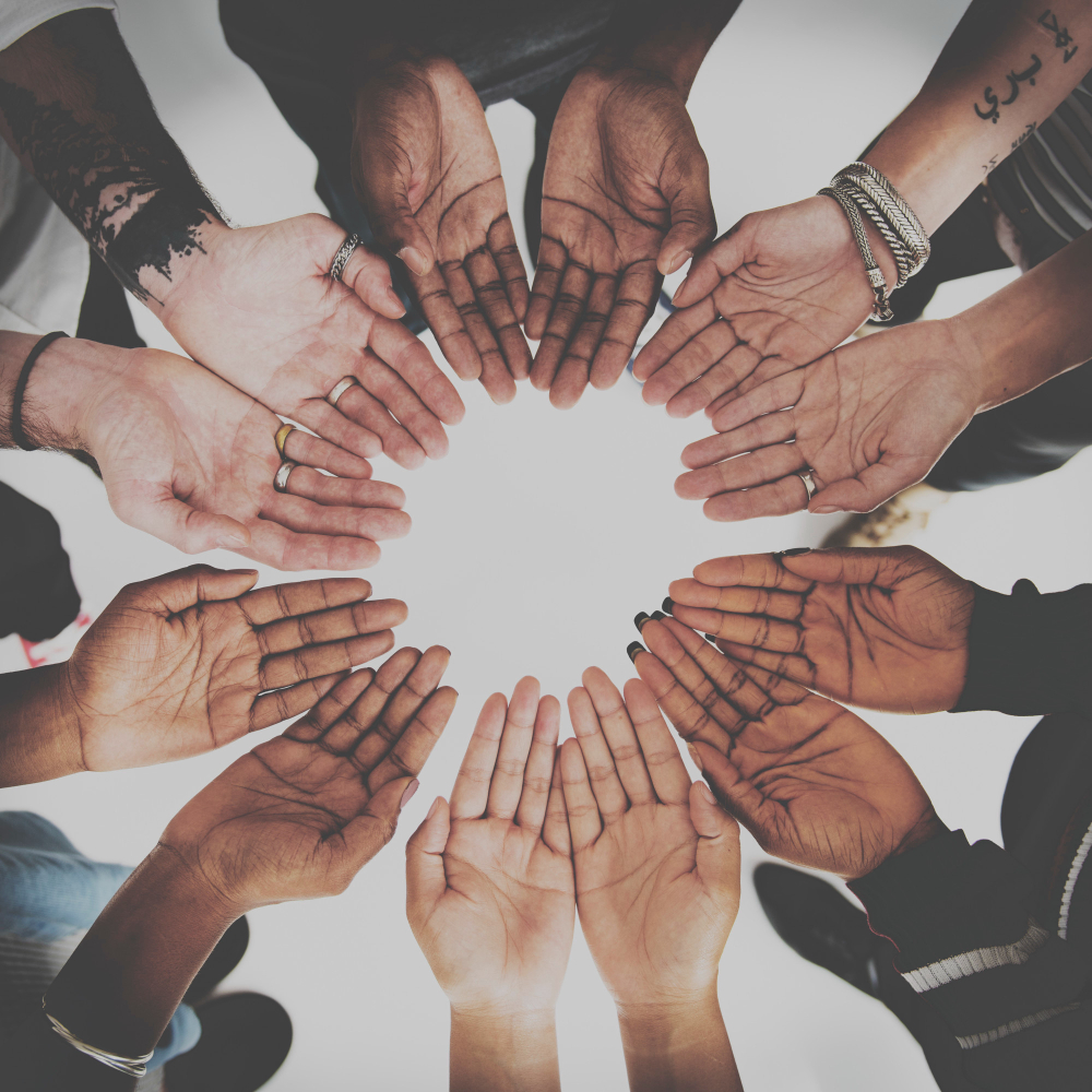photo of many human hands in a circle different skin tones